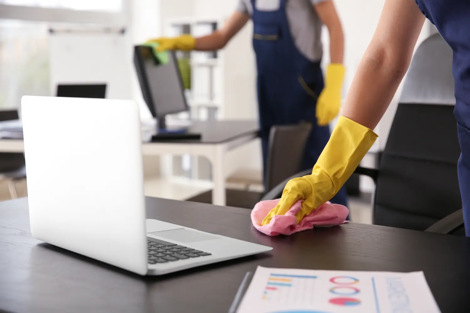 Hausmeister wischt Tisch im Büro ab